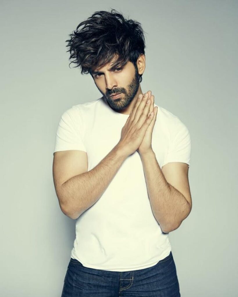 Kartik Aryan Hairstyle - posing for camera standing wear, white tshirt and black jeans