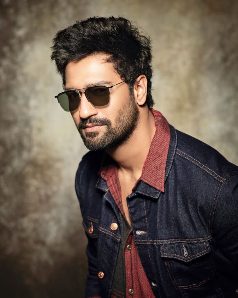 Vicky Kaushal Hairstyle - wearing black shades, red shirt and black denim