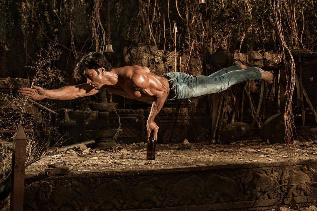 Vidyut Jamwal Top Model India - He is performing action in the picture, balancing his body on a single bottle