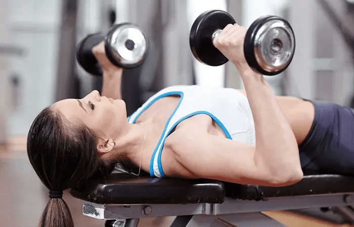 Dumbbell Chest Press - woman in her sports wear