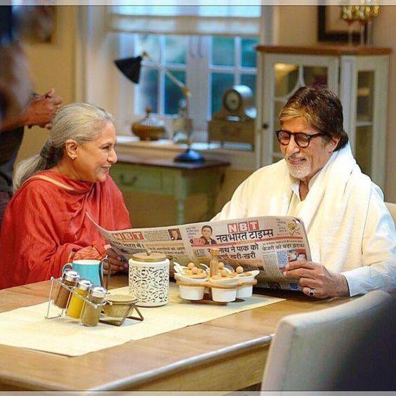 Jaya Bachchan Weds October born Amitabh Bachchan both are sitting and smiling - Amitabh is reading newspaper
