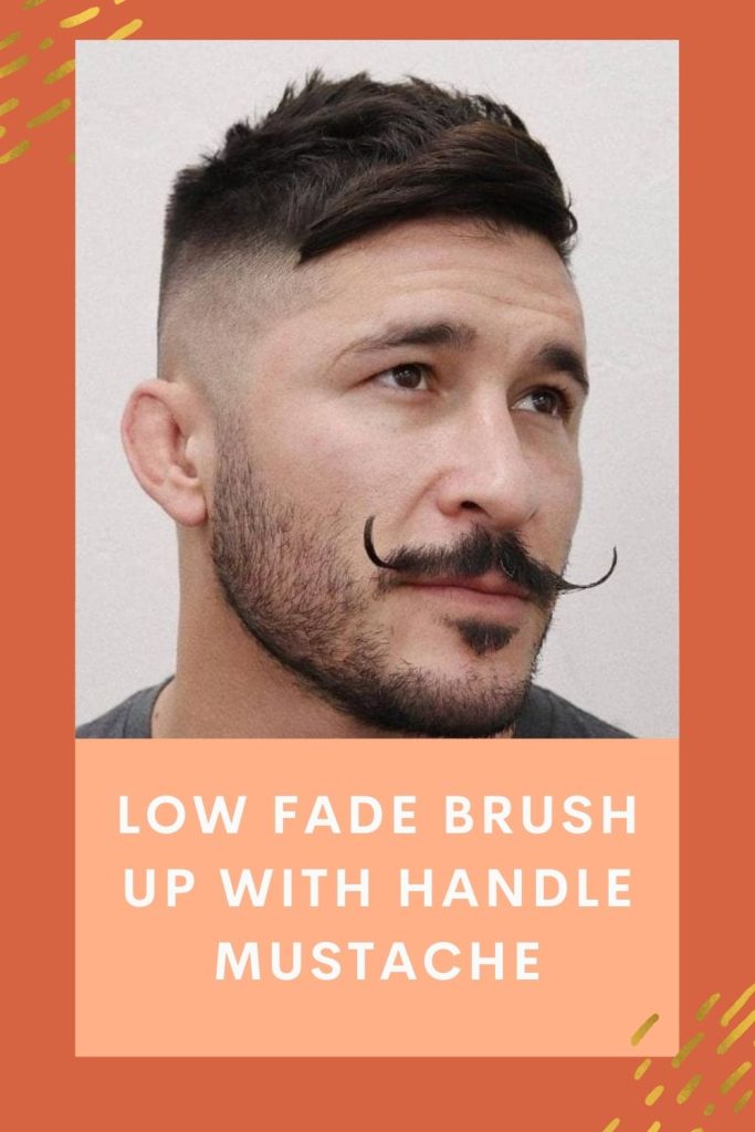 A man is giving a side look and showing off his Low fade brush up with handle mustache -  long mustache