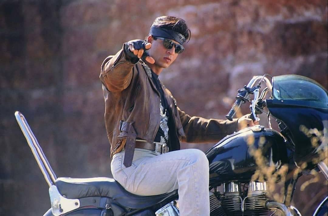 Shahrukh khan sitting on a bike and posing for camera - shahrukh khan big hair style