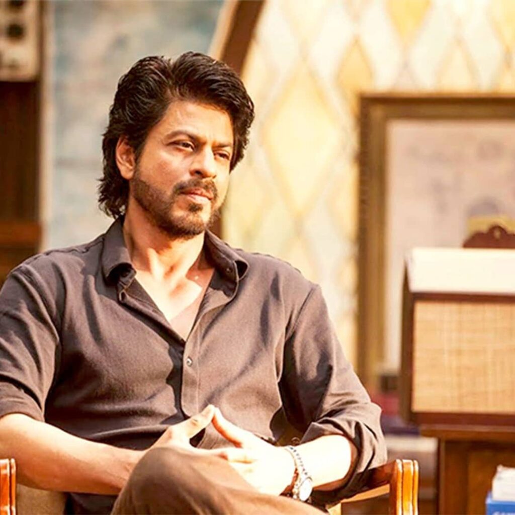 Shahrukh sitting in a brown shirt and thinking about something - shahrukh khan hairstyle photos