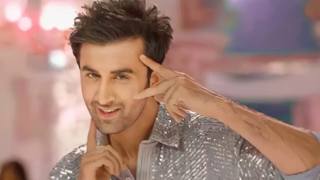 Ranbir in shiny grey outfit smiling and posing for camera - Ranbir Kapoor latest hairstyles