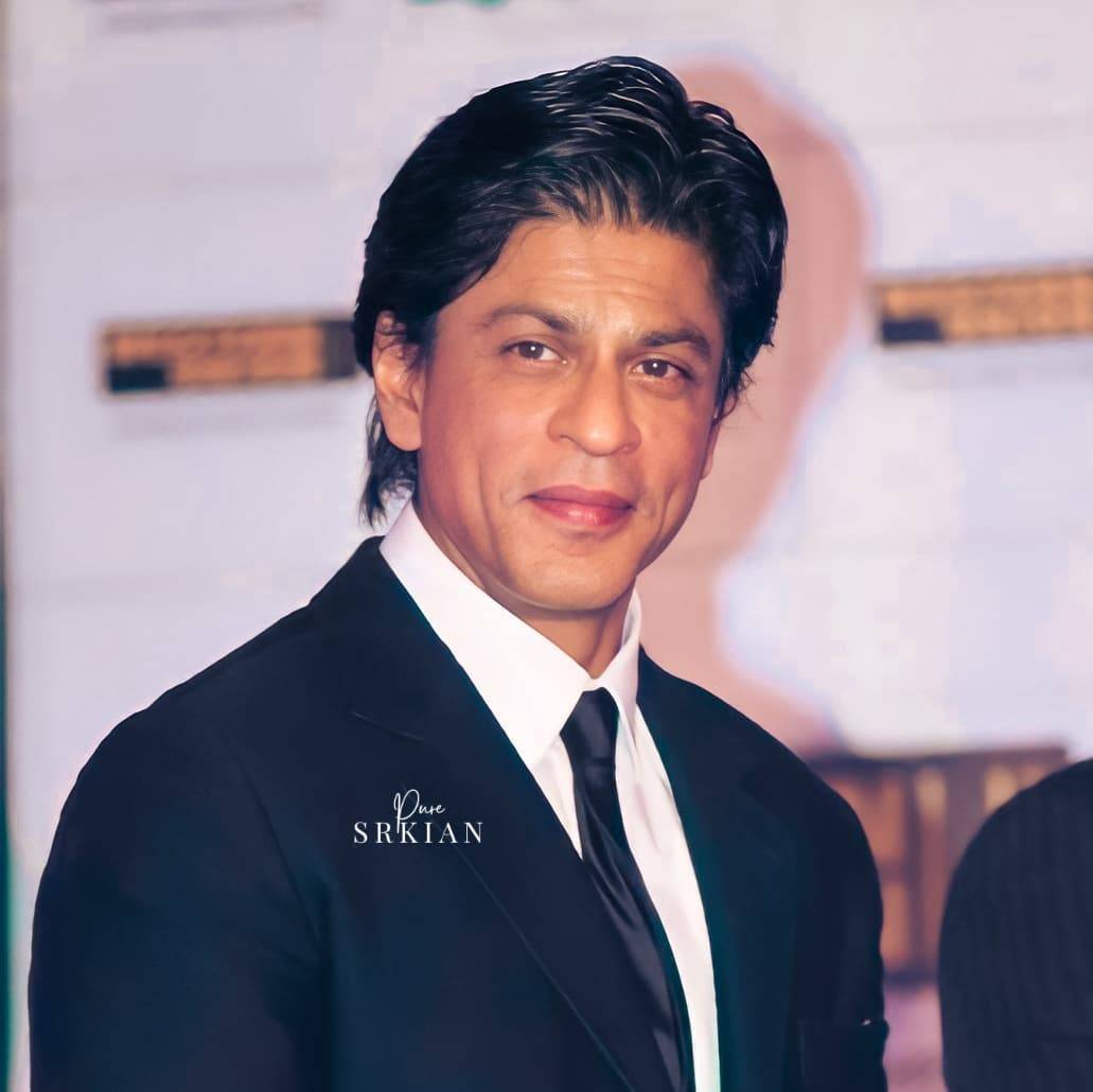 Smiling Shahrukh in Blue suit posing with Slick Back look - shahrukh khan short haircut