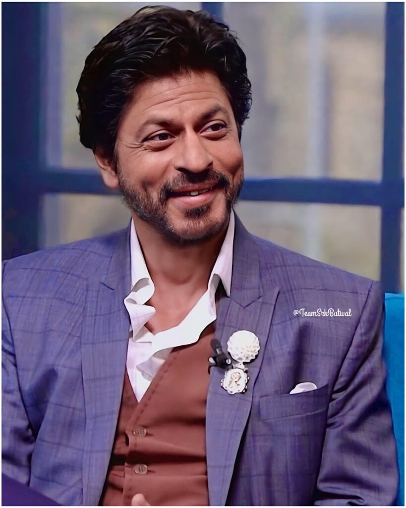 Smiling Shahrukh Khan wearing a blue coat with white shirt - shahrukh khan best hairstyles