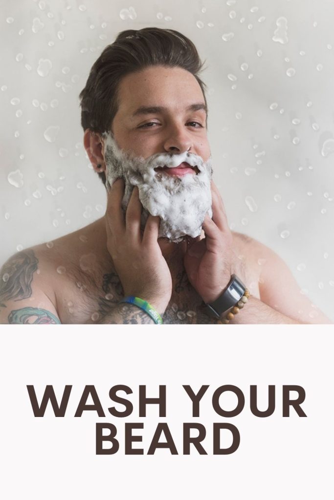 A guy with tattoos washing his beard - beard grooming kit 