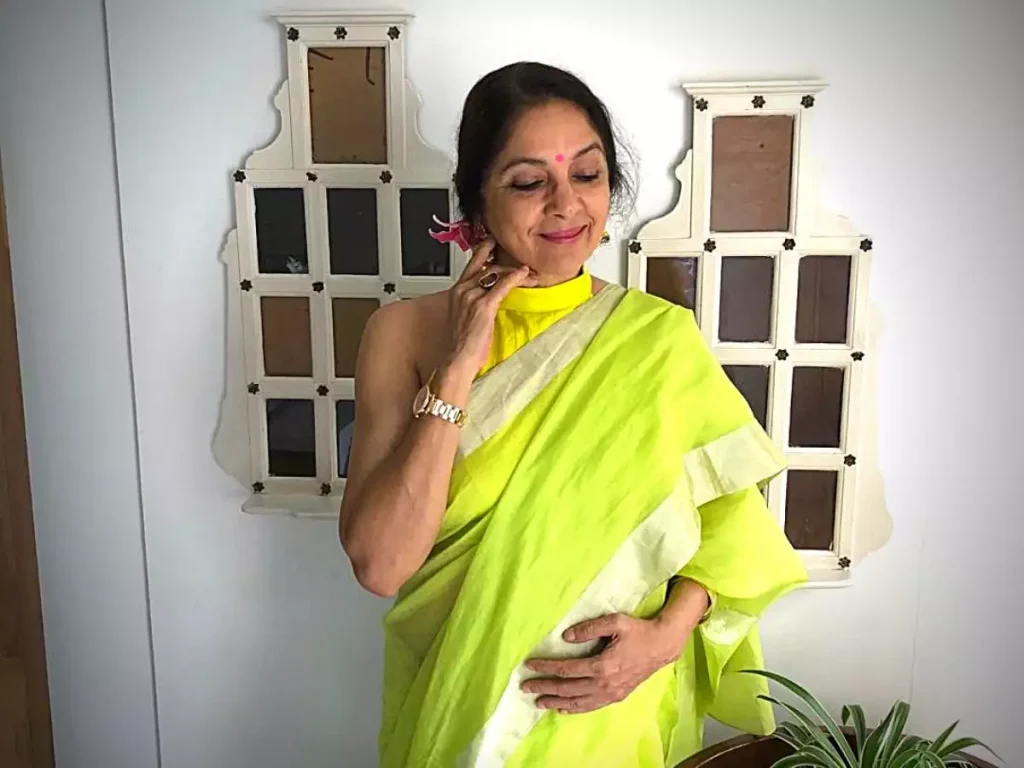 Neena Gupta in yellow saree with off shoulder blouse smiling and posing - Indian Actress Who became Pregnant before Marriage