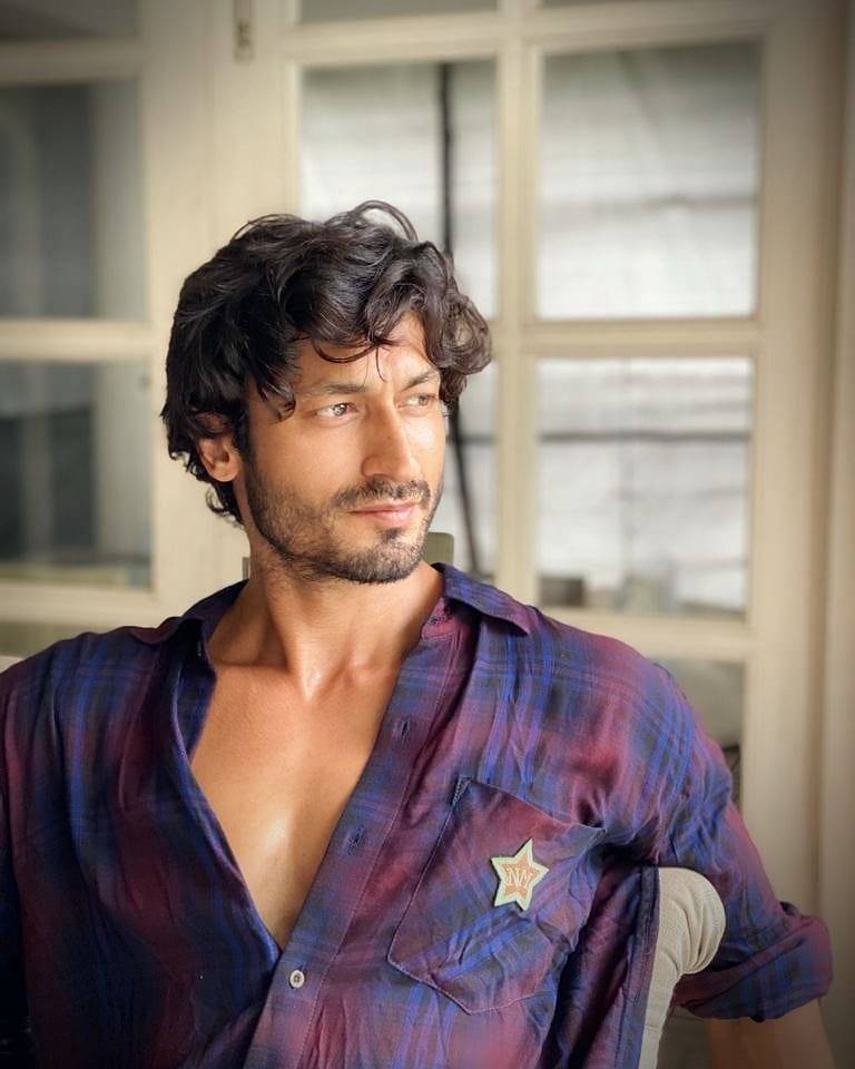 Vidyut Jammwal sitting in multi color shirt showing his Short and curly hairstyle - Vidyut Jammwal hairstyle 2021