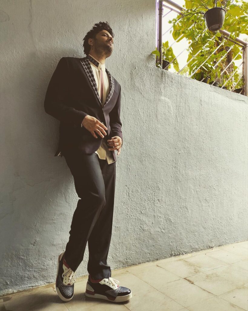 Ali Fazal in black suit standing and posing for camera - Ali Fazal hairstyle 2021
