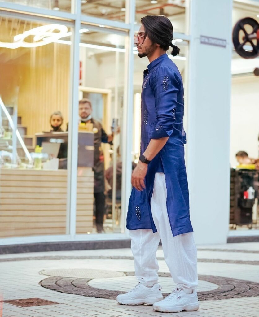 Faisal Khan in traditional blue kurta and white payjama with sports shoes showing his low ponytail - Mr. faisu hairstyle 2021