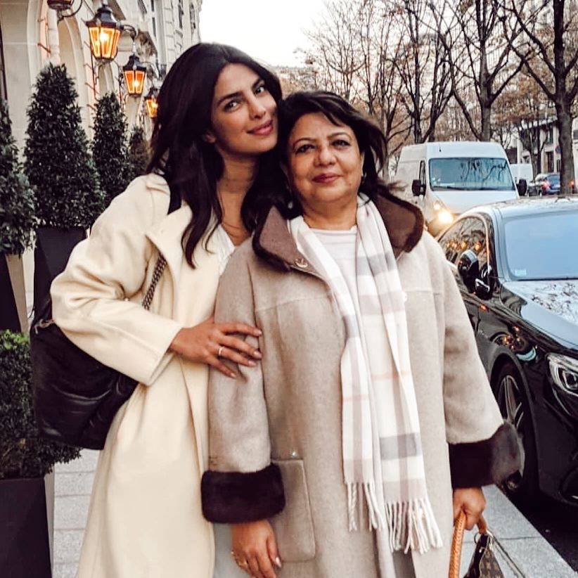 Priyanka Chopra in a long coat posing for camera with her mom - priyanka chopra hairstyles