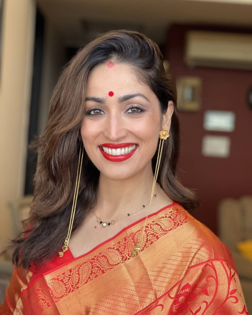 smiling Yami Gautam in traditional saree posing for camera - Indian actress hairstyle pictures