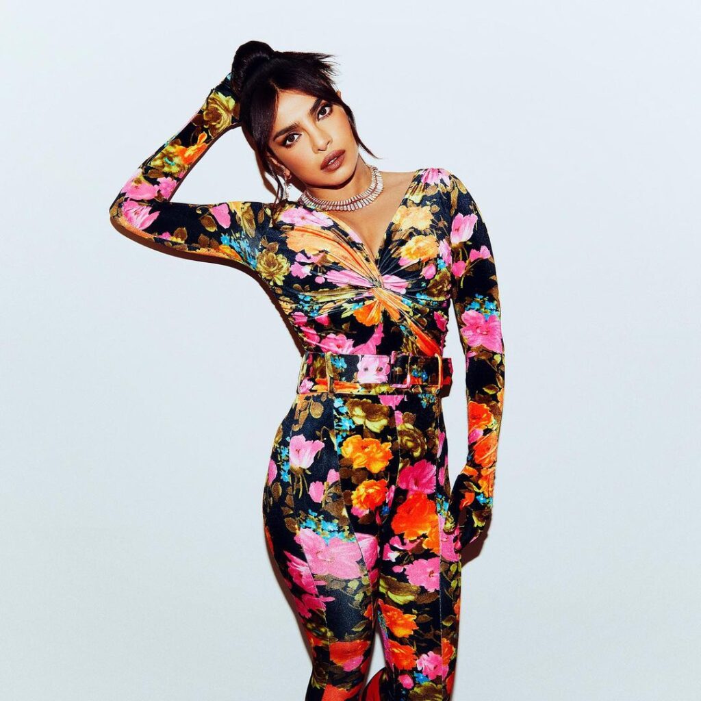Priyanka Chopra in Multicolor fitted jumpsuit posing for camera and showing her high bun - haircut name