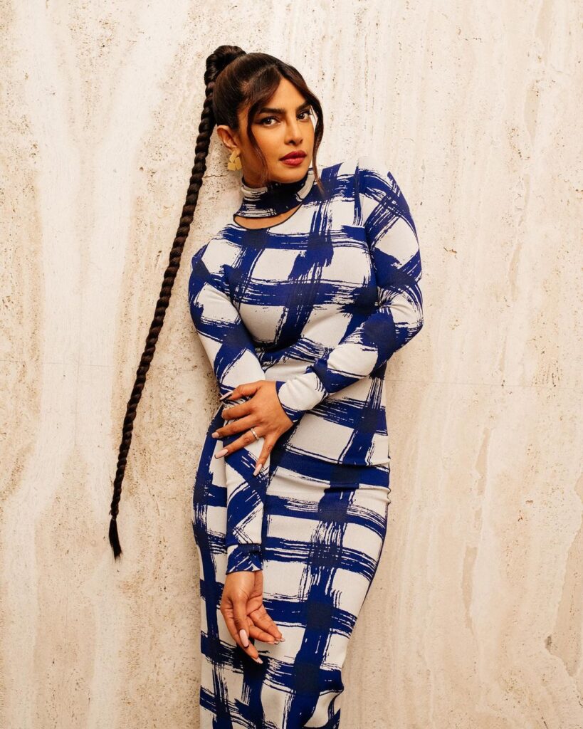 Priyanka Chopra in blue and white check dress posing for camera and showing her long braid - Priyanka chopra hairstyle in matrix
