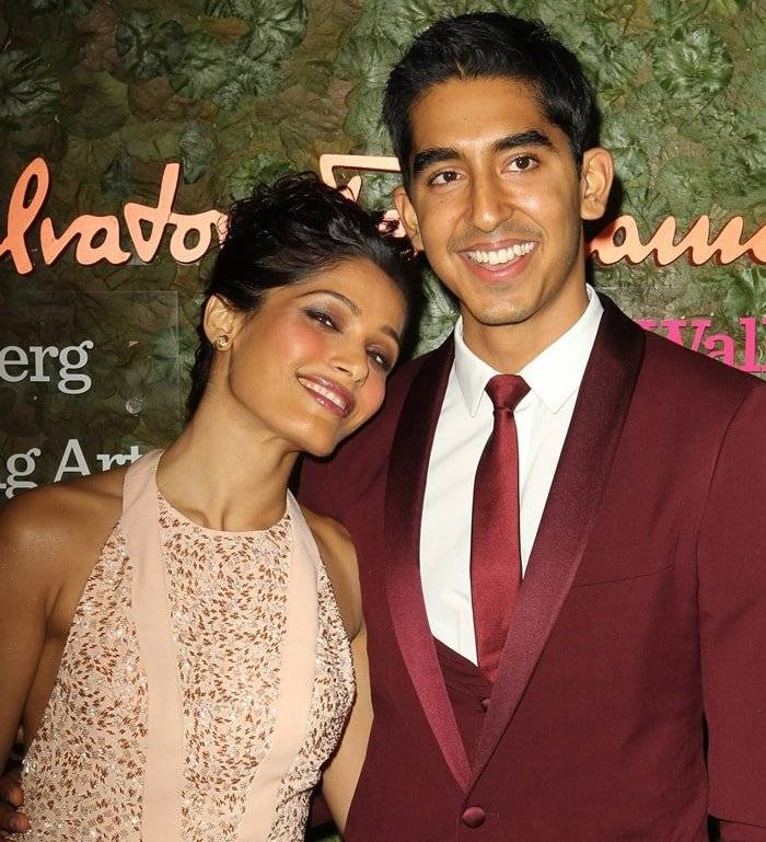 Dev Patel in maroon suit and Freida Pinto in pink dress posing for camera - indian celebrities live in relationship