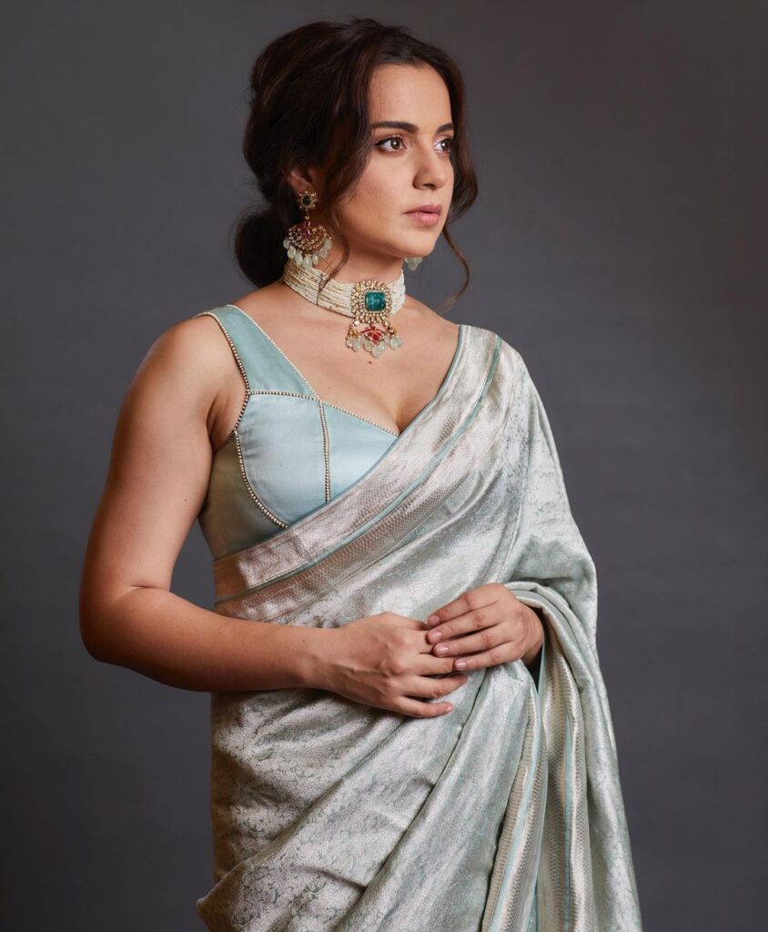 Kangana Ranaut in light blue saree and Loose low bun with bangs posing for camera - late 30s women hairstyles