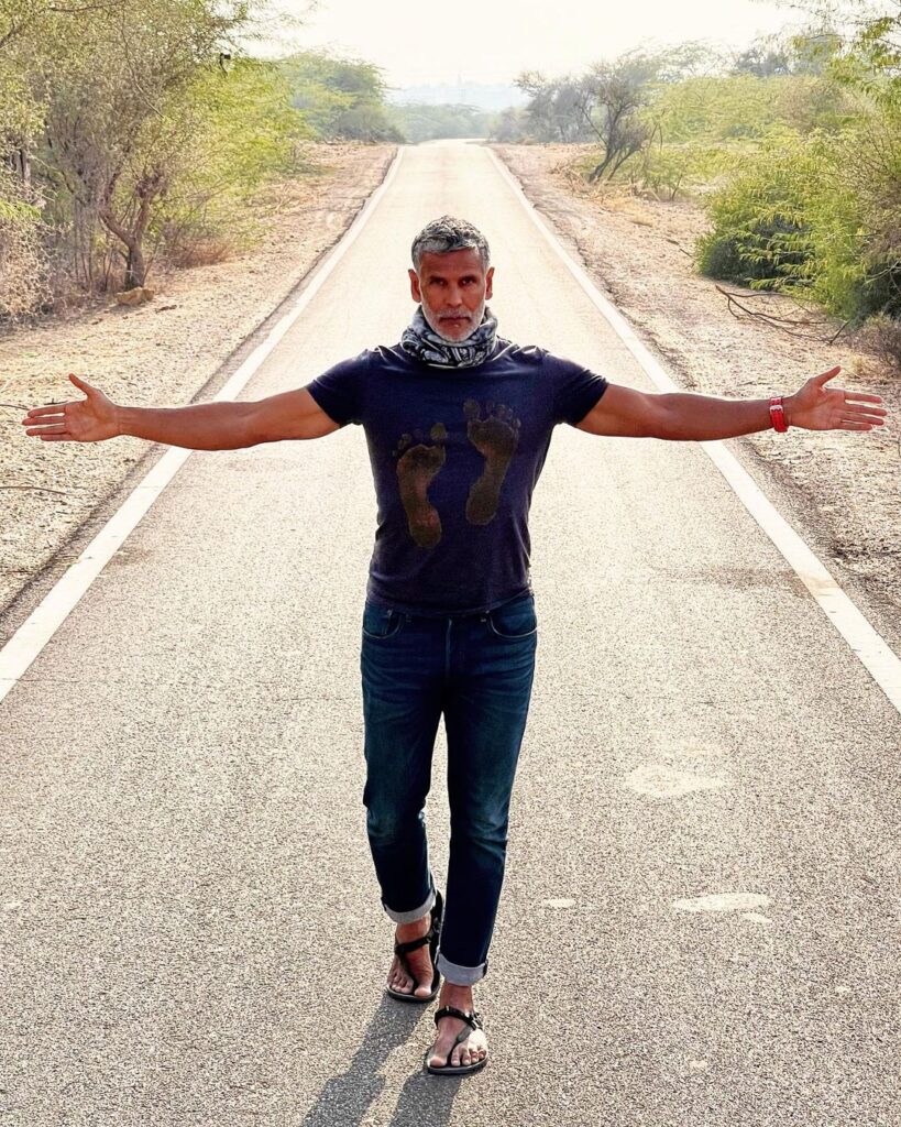 Milind Soman posing for camera n a road in blue t-shirt - male models in India 2022