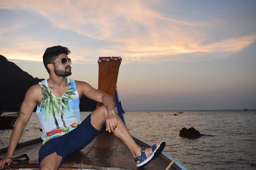 Prateik Jain sitting on a boat in multicolor printed t-shirt - models in India
