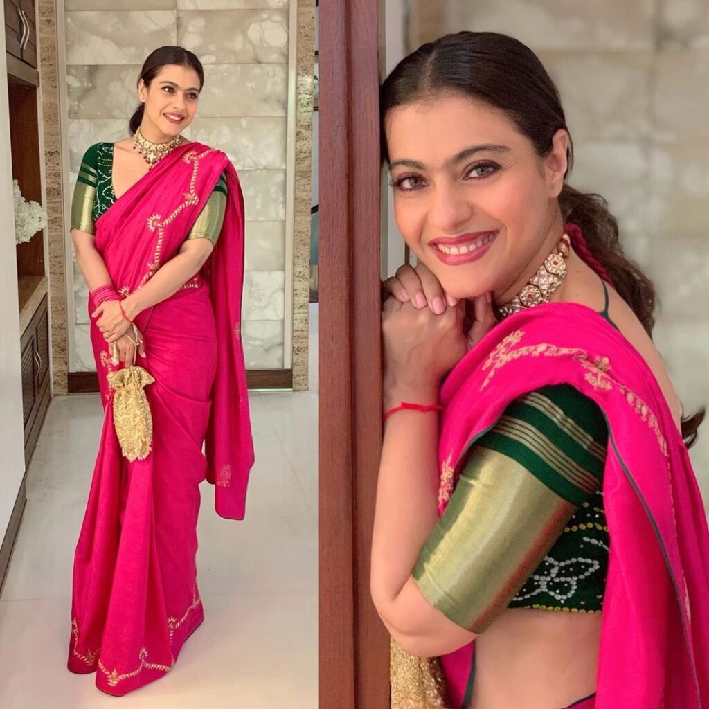 Smiling Kajol in pink sari and necklace with clean low ponytail posing for camera - hairstyles for working women