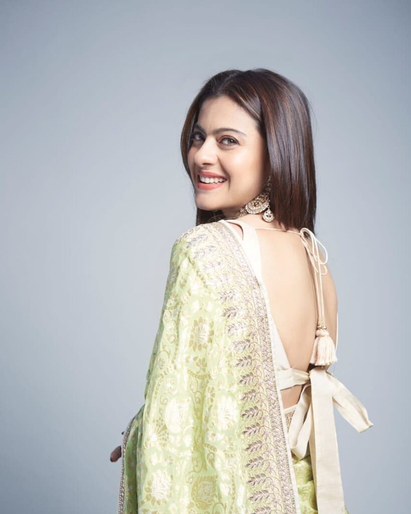 Kajol in light green color saree and deep blouse with straight hair posing for camera - hair color