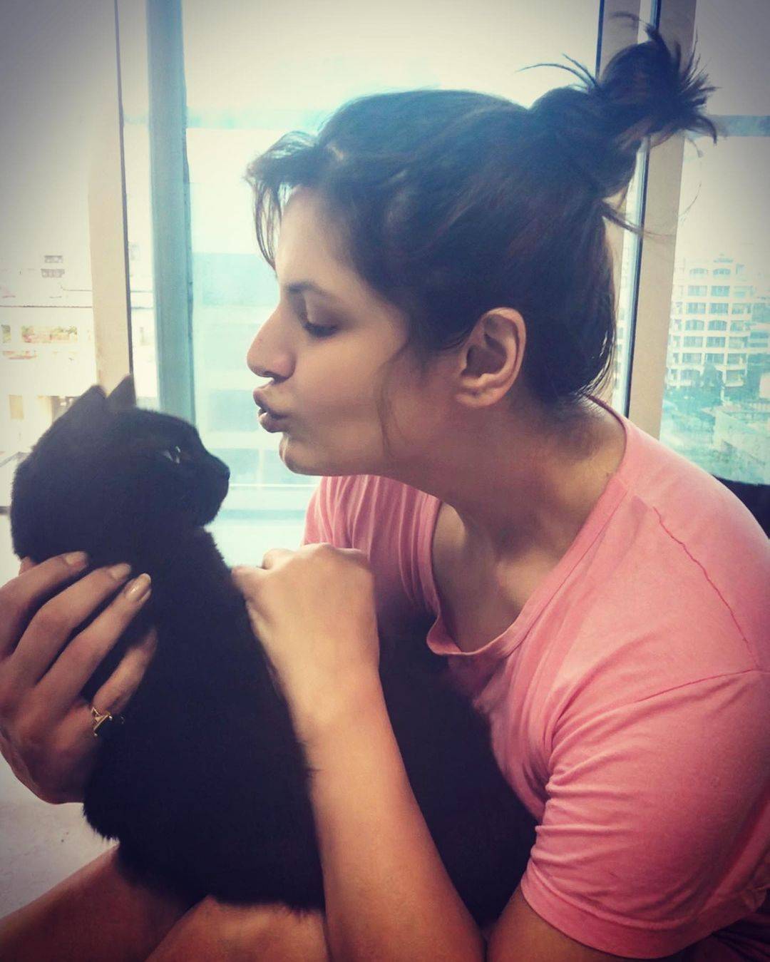 Zareen Khan posing with her cat in messy bun - professional hairstyles