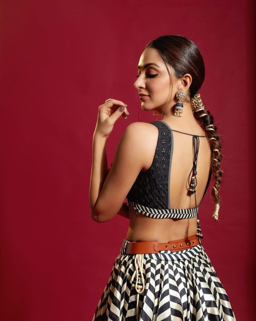 Kiara Advani in black and white dress posing for camera and showing her Braid with accessories - hair color in 2022