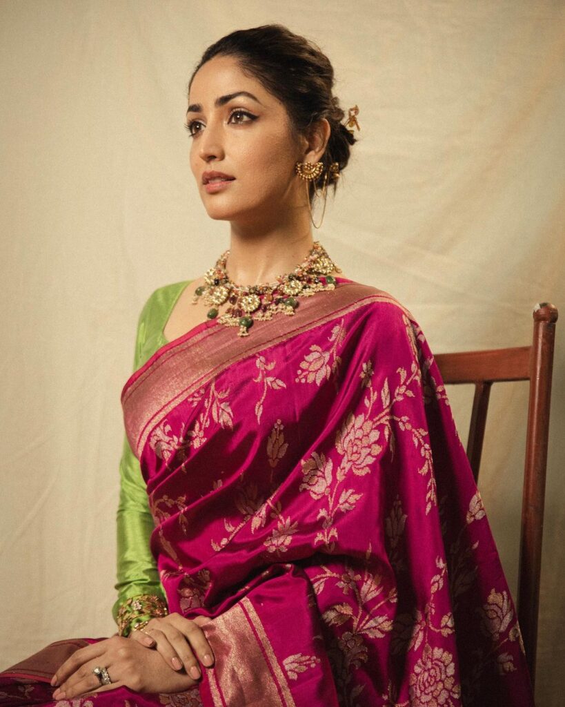 Yami Gautam in pink saree and green blouse and messy tight bun posing for camera - woman hair care regime