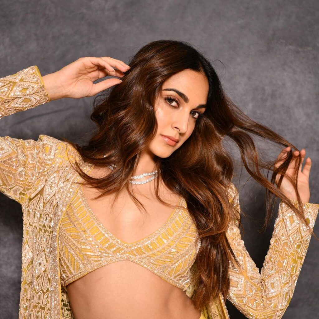 Kiara Advani in yellow and golden dress posing for camera and showing her Beachy waves - hairstyles for thin girls