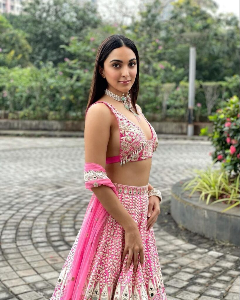 Kiara Advani in pink and white lehenga posing for camera and showing her Center parted sleek and straight hair - celebrity hairstylist 