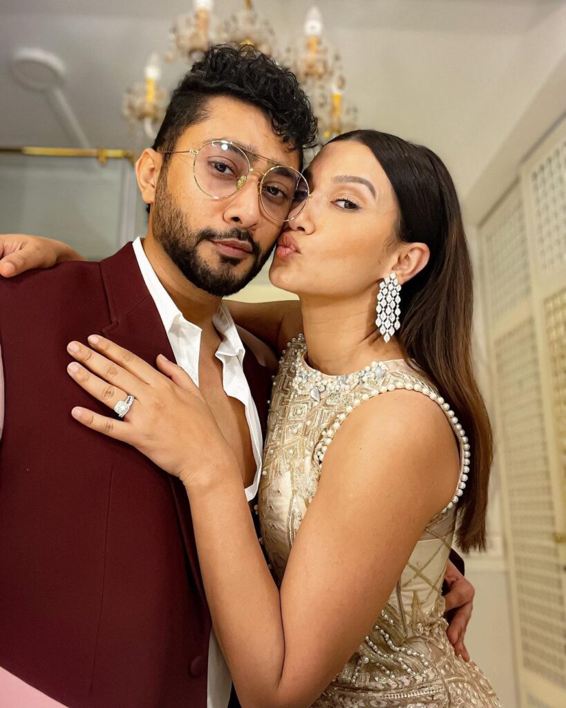 Gauhar Khan in white dress and Zaid Darbar in maroon coat posing for a selfie - celebrity couple india