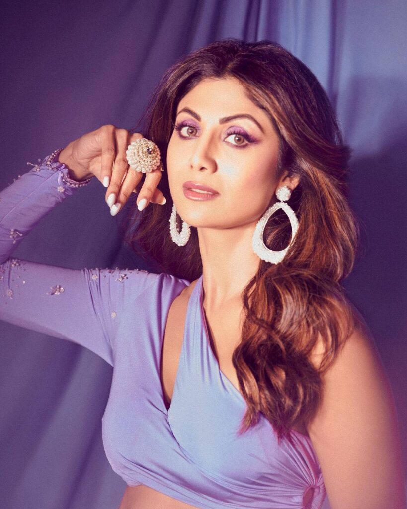 Shilpa Shetty in purple dress with pearl earing posing for camera - 40s Women’s hairstyles