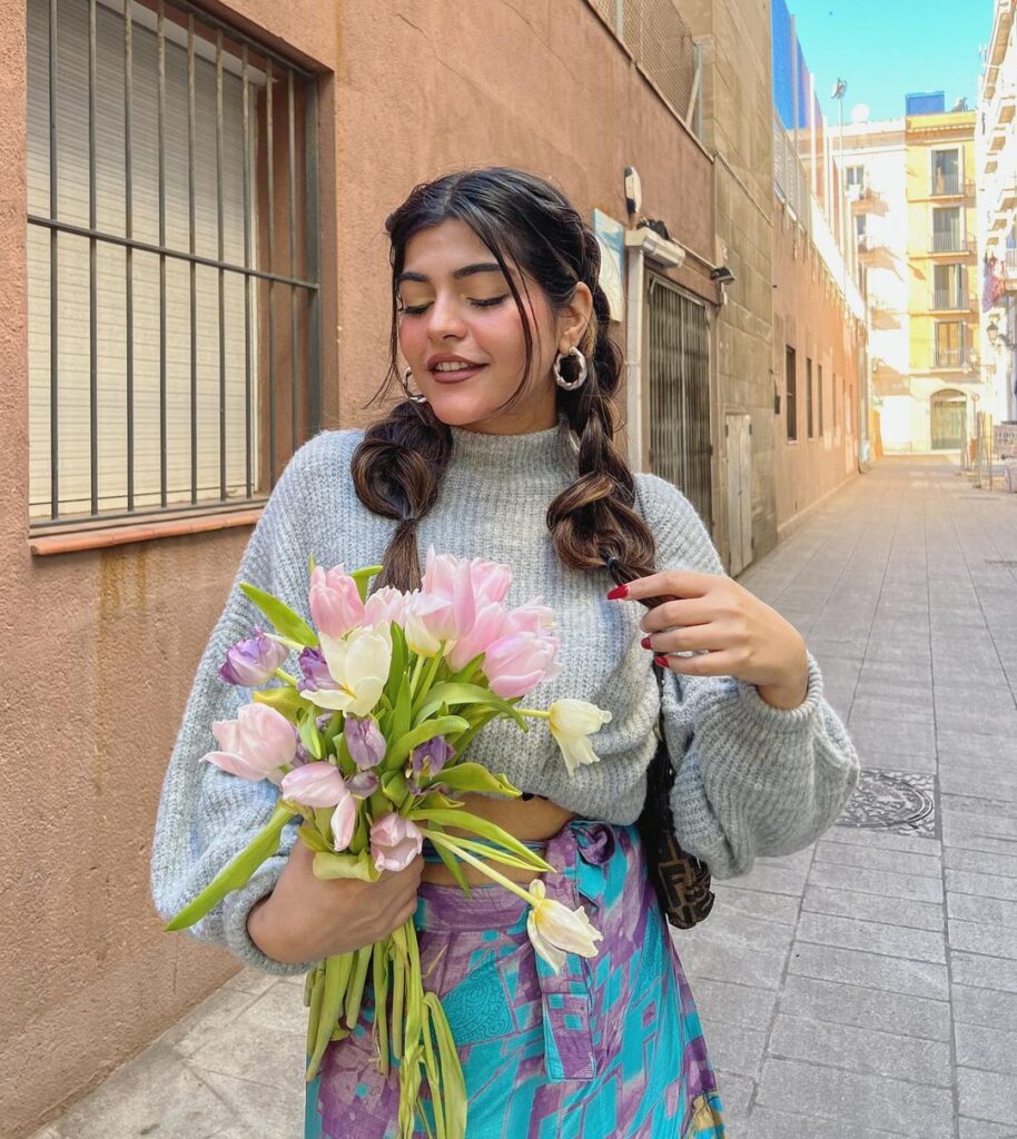 Kritika Khurana in holding flowers and pigtails with multiple hair ties -   hairstyle for oval face shape
