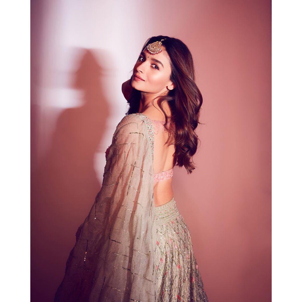 Alia Bhatt in grey lehenga and deep neck blouse posing for camera and showing her wavy curls - hairstyles for working women 