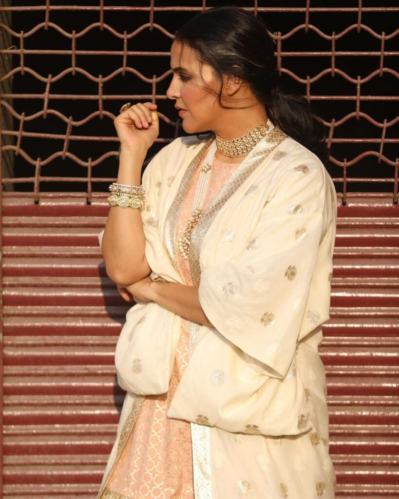 Neha Dhupia in off white traditional dress and jewellery posing for camera and showing her side look - Long Hair