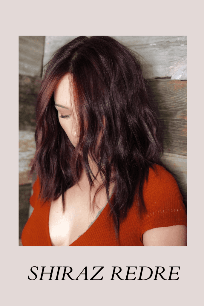 A girl in red deep neck top top showing her Shiraz Redre hair color - trending hair color