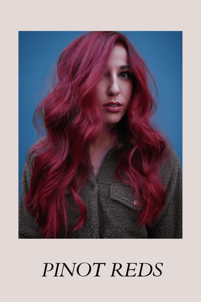 A girl in grey sweater posing for camera  and showing her Pinot Red hair color - Red hair color