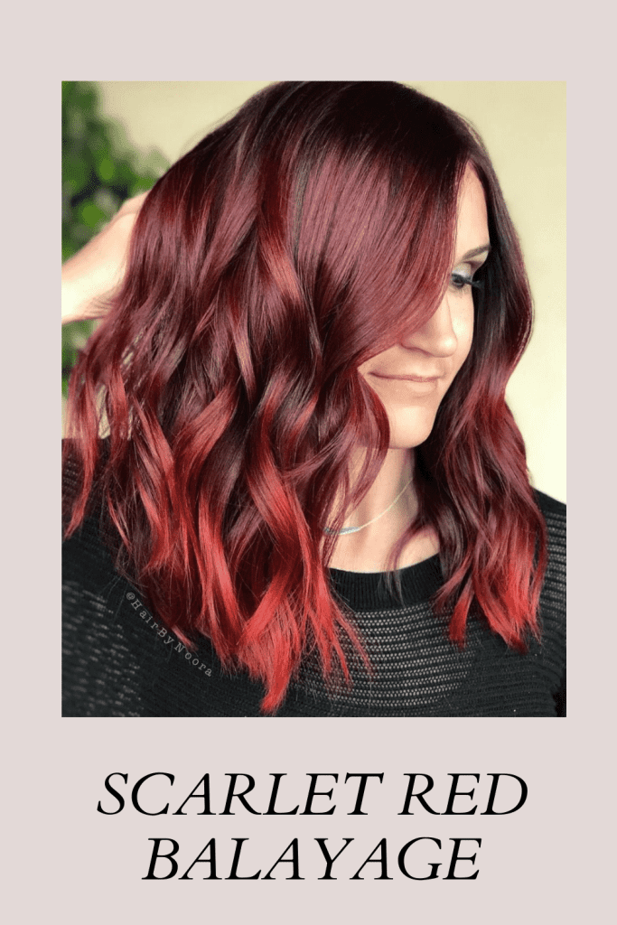 A girl in black net top showing her Scarlet Red Balayage hair color - trending hair color