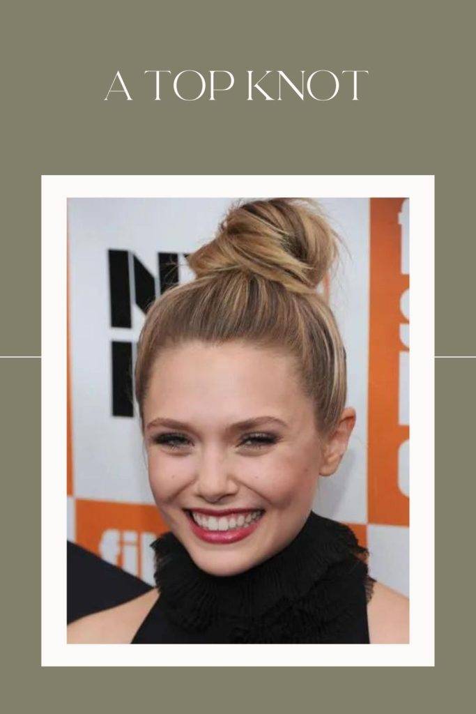 A smiling girl in black high neck top showing her top knot hairstyle - hairstyles for oval face 2022