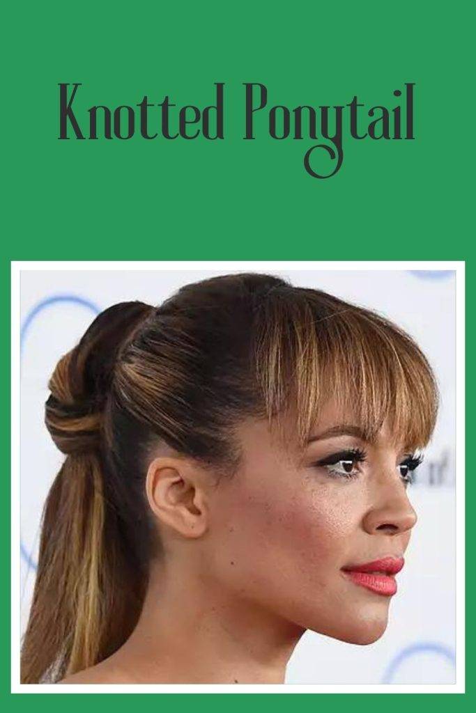 A girl with pink lipstick and knotted ponytail with curtain bangs - working women hairstyles