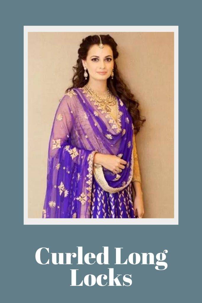 Dia Mirza in blue and golden lehenga posing for camera and showing her Curled long locks - ponytail hairstyles