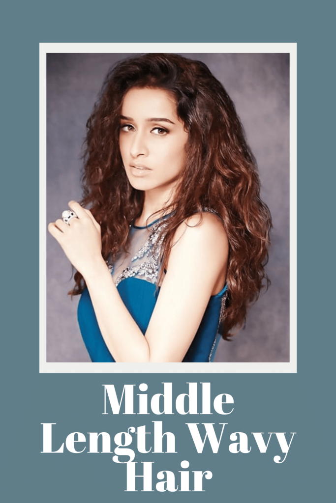 Shraddha Kapoor in blue top posing for camera and showing her middle length wavy hair - Oval face shape