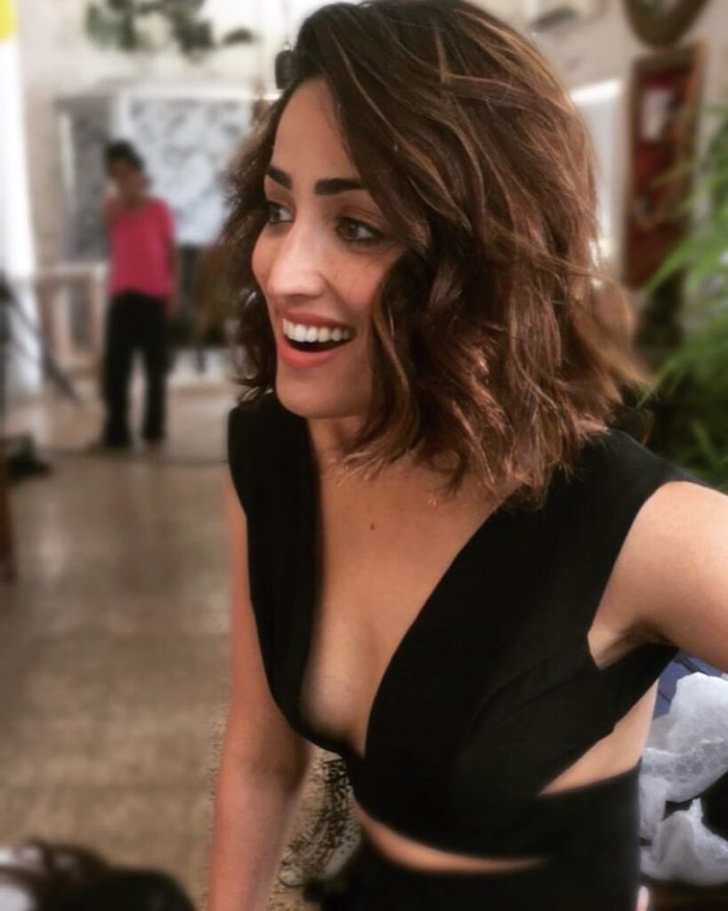 Yami Gautma in black deep neck dress posing for a selfie and showing her short wavy hair - short hair