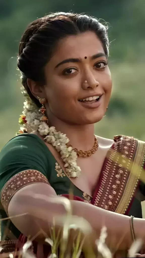 Smiling Rashmika Mandanain in saree and green blouse showing her Long Braid with Gajra hairstyle - Rashmika Mandanna haircut name