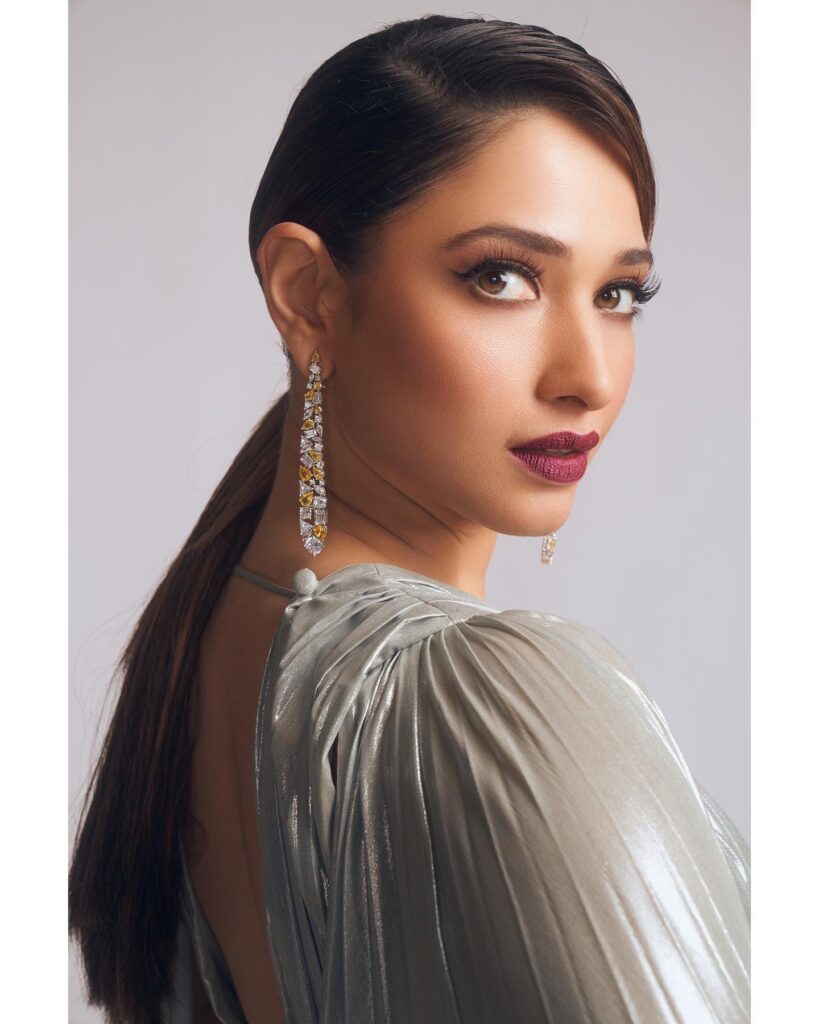Tamannah Bhatia in grey dress with long earrings posing for camera and showing her Side Parted Sleek Ponytail - hair care regime