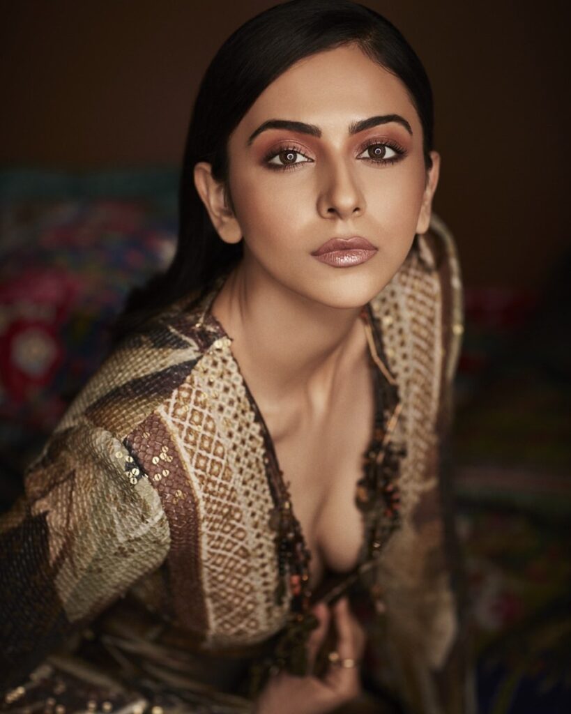 Rakul Preet Singh in deep neck brown dress and nude makeup posing for camera and showing off her gelled hair - celebrity hairstylist