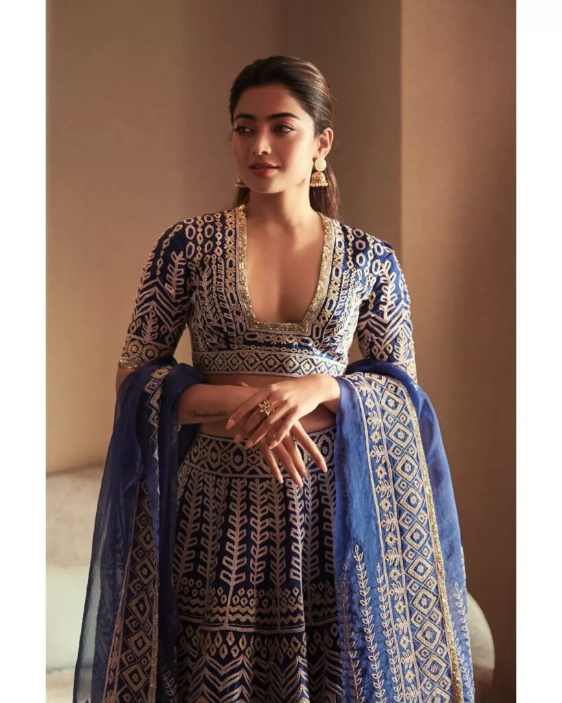 Rashmika Mandanain in deep neck blouse blue and lehenga posing for camera and showing her half tie hair - hair care regime