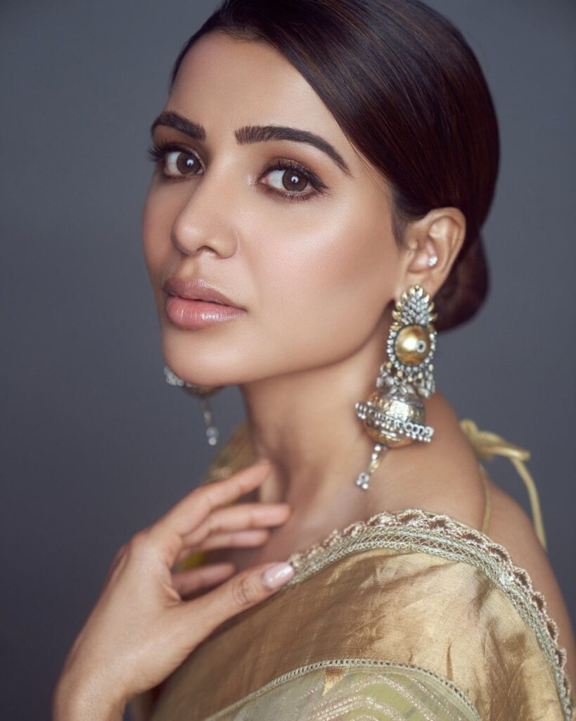 Samantha in golden saree with matching danglers posing for camera and showing her clean low bun - Samantha Ruth Prabhu haircut name