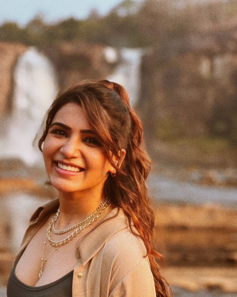 Smiling Samantha in light brown open shirt with green inner posing for camera and showing her half up half down hairstyle - hair color